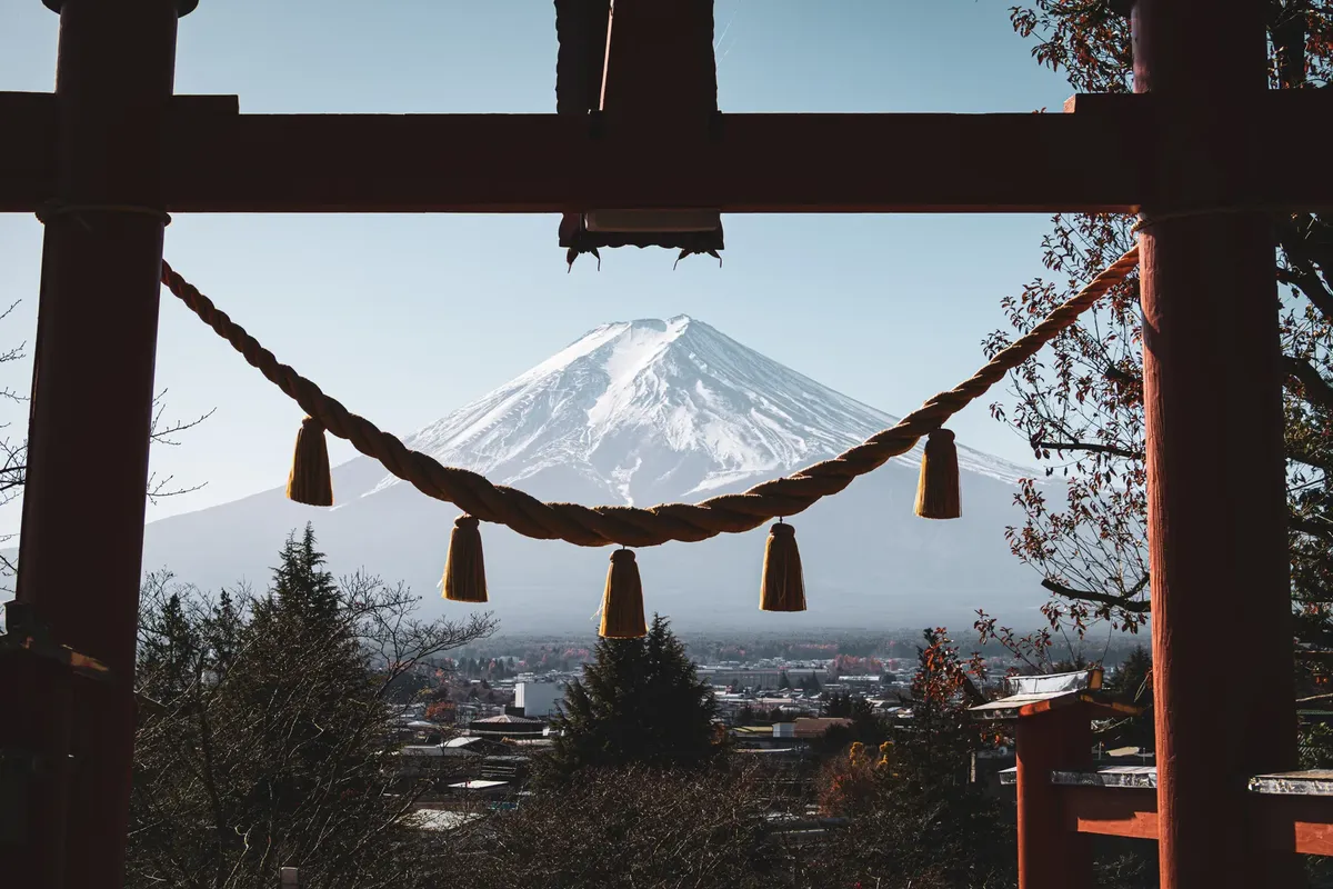 Mount Fuji framed by a traditional torii gate in Fujiyoshida, Japan, showcasing serenity and cultural beauty.